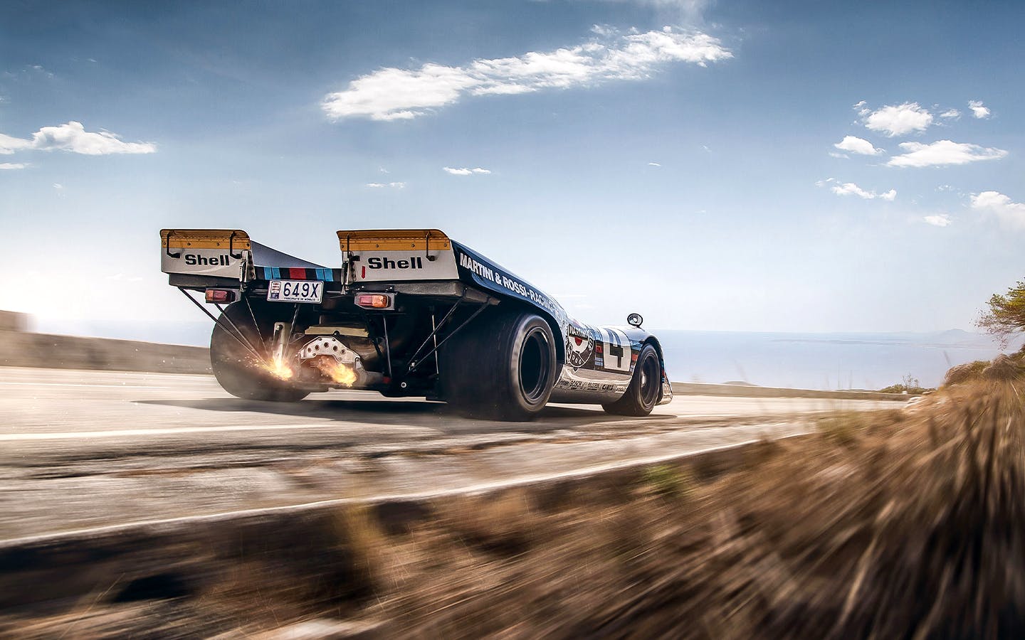 Rear view of Porsche 917-037 road car driving on coastal road