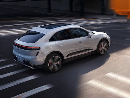 White electric Porsche Macan Turbo driving across road junction