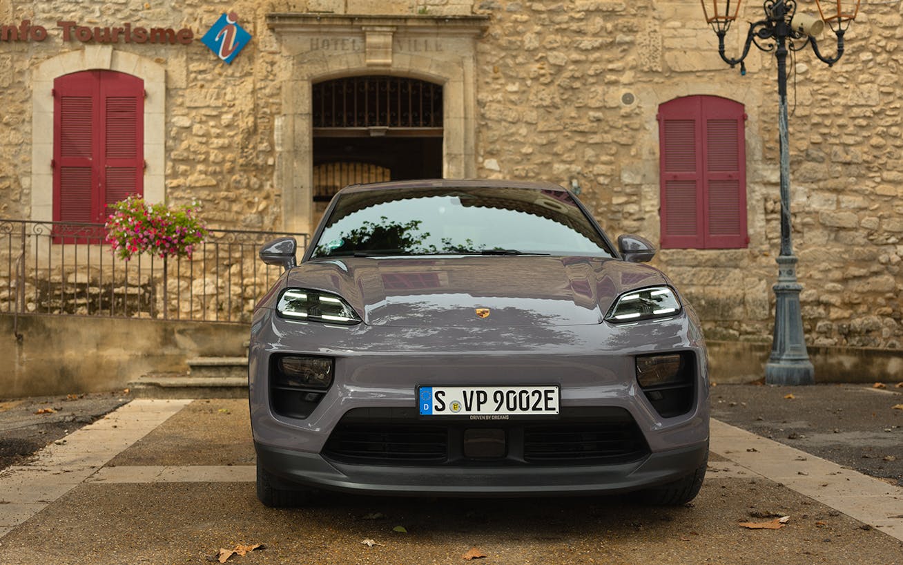 Porsche Macan 4 Electric parked outside traditional Provençal stone building