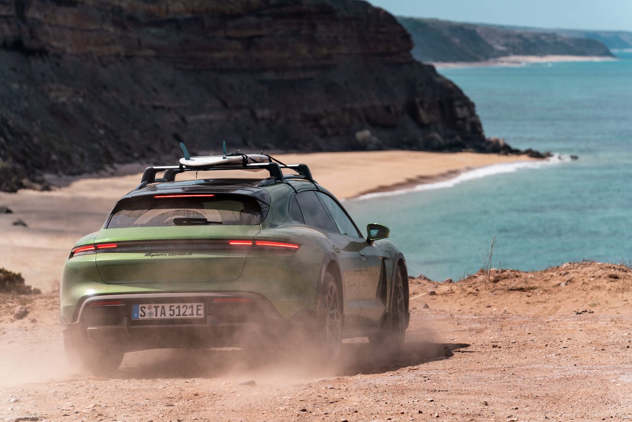 Green Porsche Taycan Turbo S Cross Turismo, beach in background