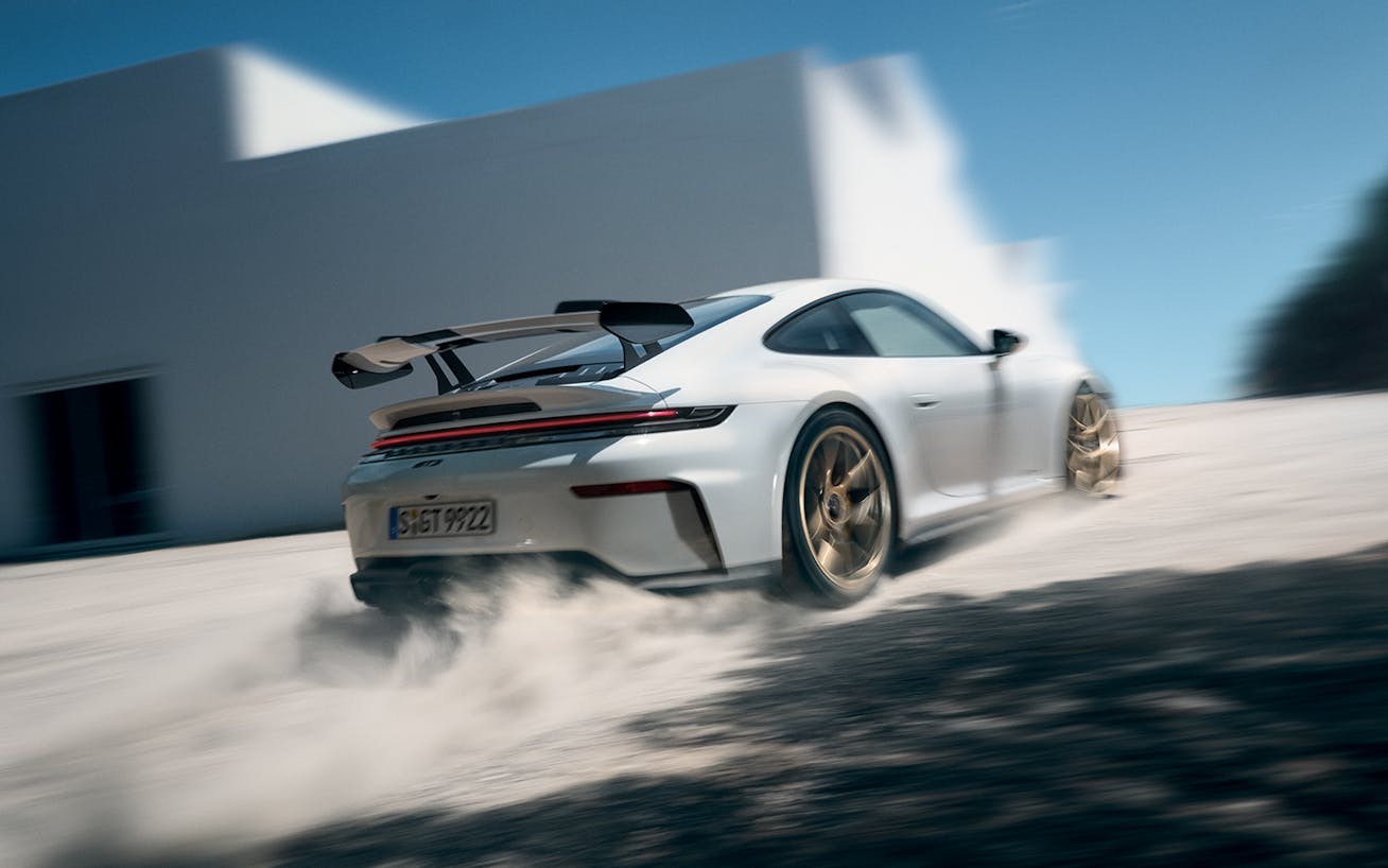 White 2024 Porsche 911 GT3 kicking up dust while accelerating