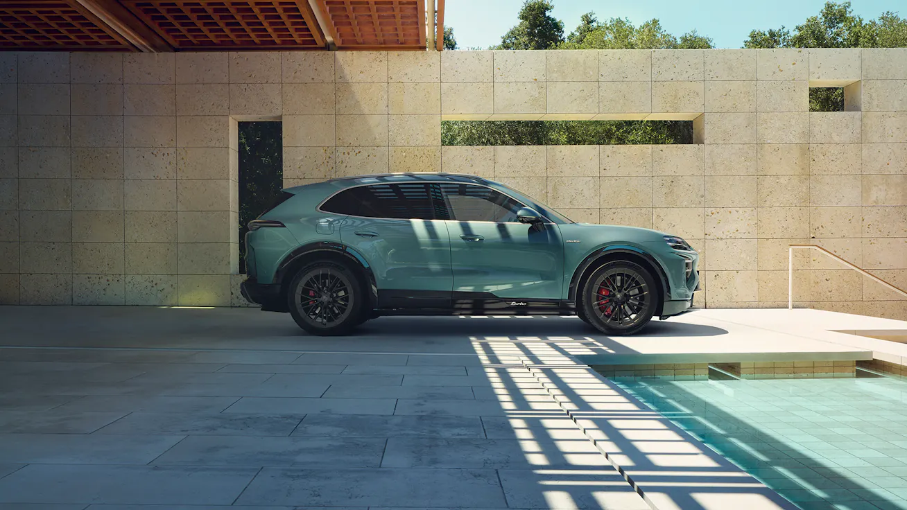 Porsche Cayenne Electric side view parked beside modern structure