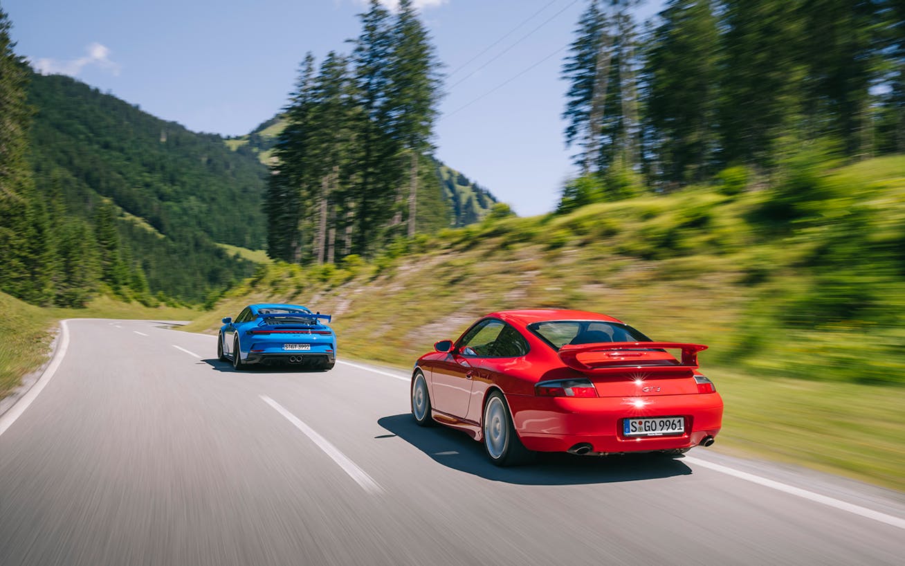 Rear view of 911 (996) GT3 and 911 (992) GT3 driving on mountain road