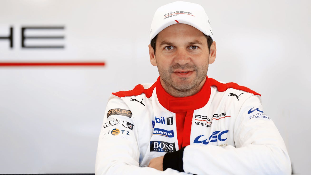 Richard Lietz, 24 Hours of Le Mans-winning driver with Porsche Motorsport, in a racesuit and Porsche Motorsport cap 