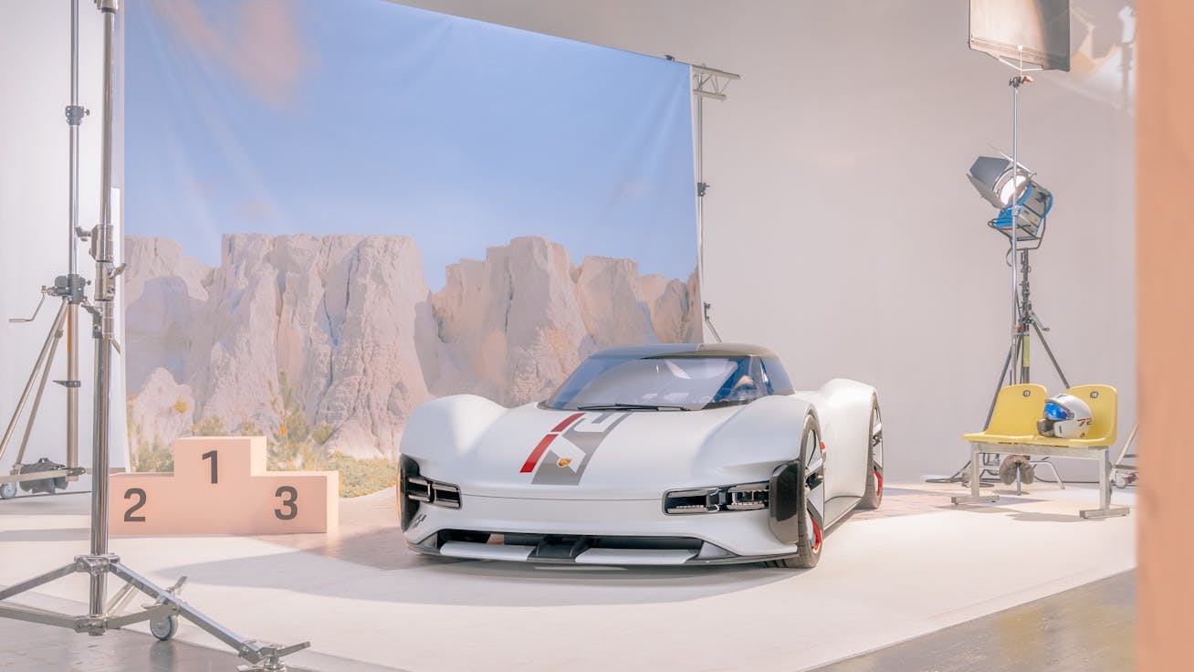 Vision Gran Turismo in a photo studio, rocky backdrop behind