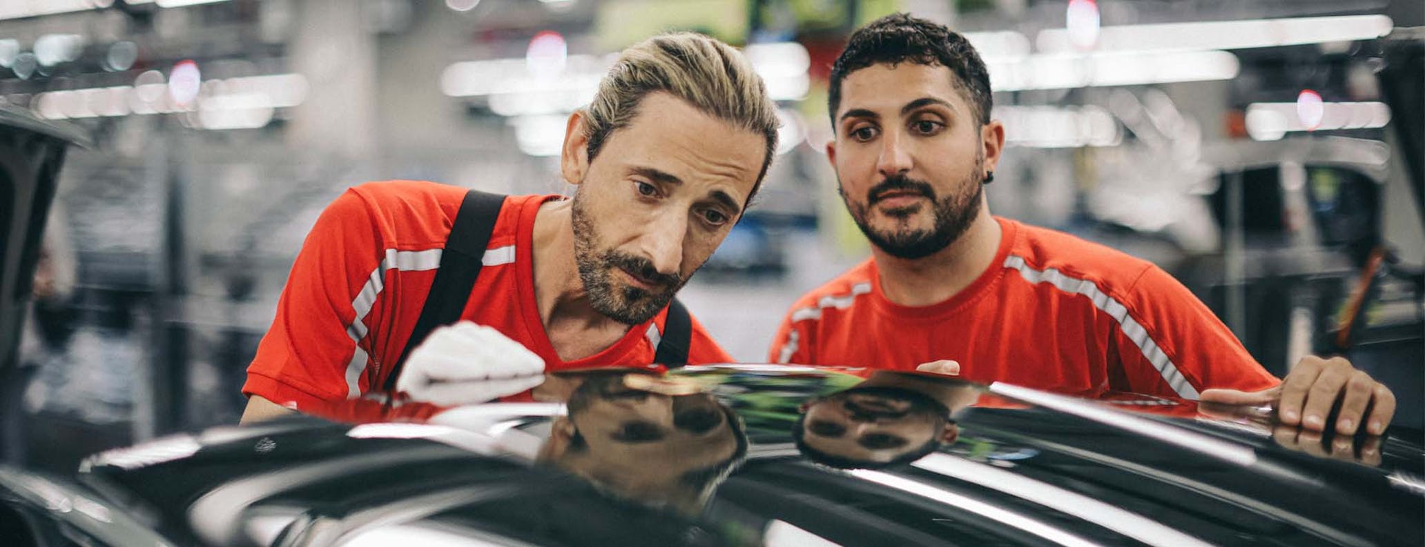 Adrien Brody working on Porsche car in factory