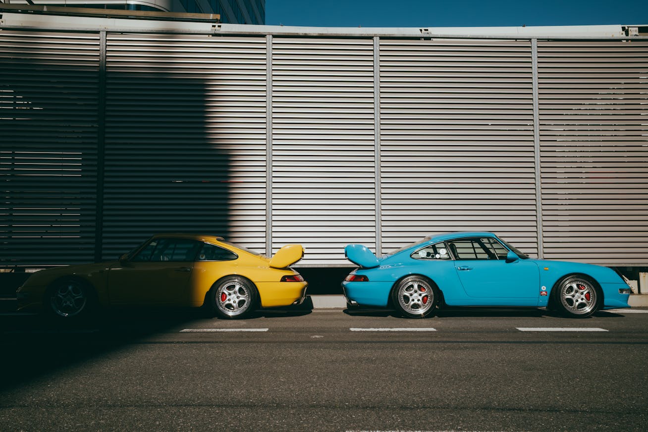 Two Porsche 911 Carrera RS (type 964) parked side-by-side on the Tokyo Expressway