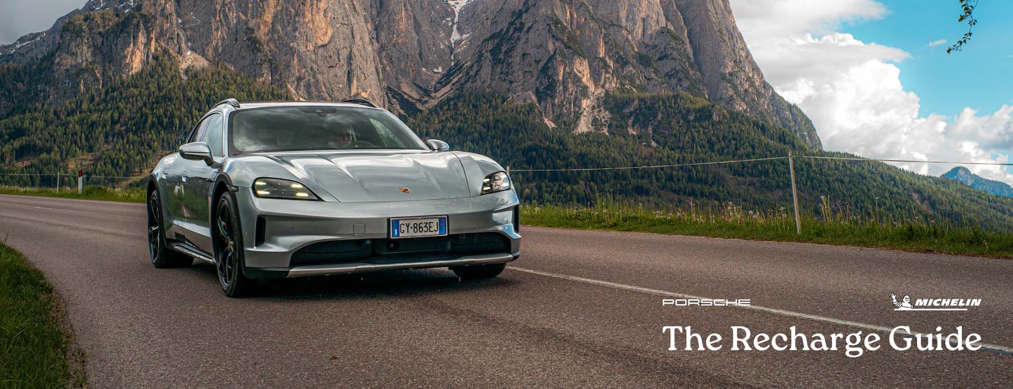 Porsche Taycan Cross Turismo driving on road, mountains in background