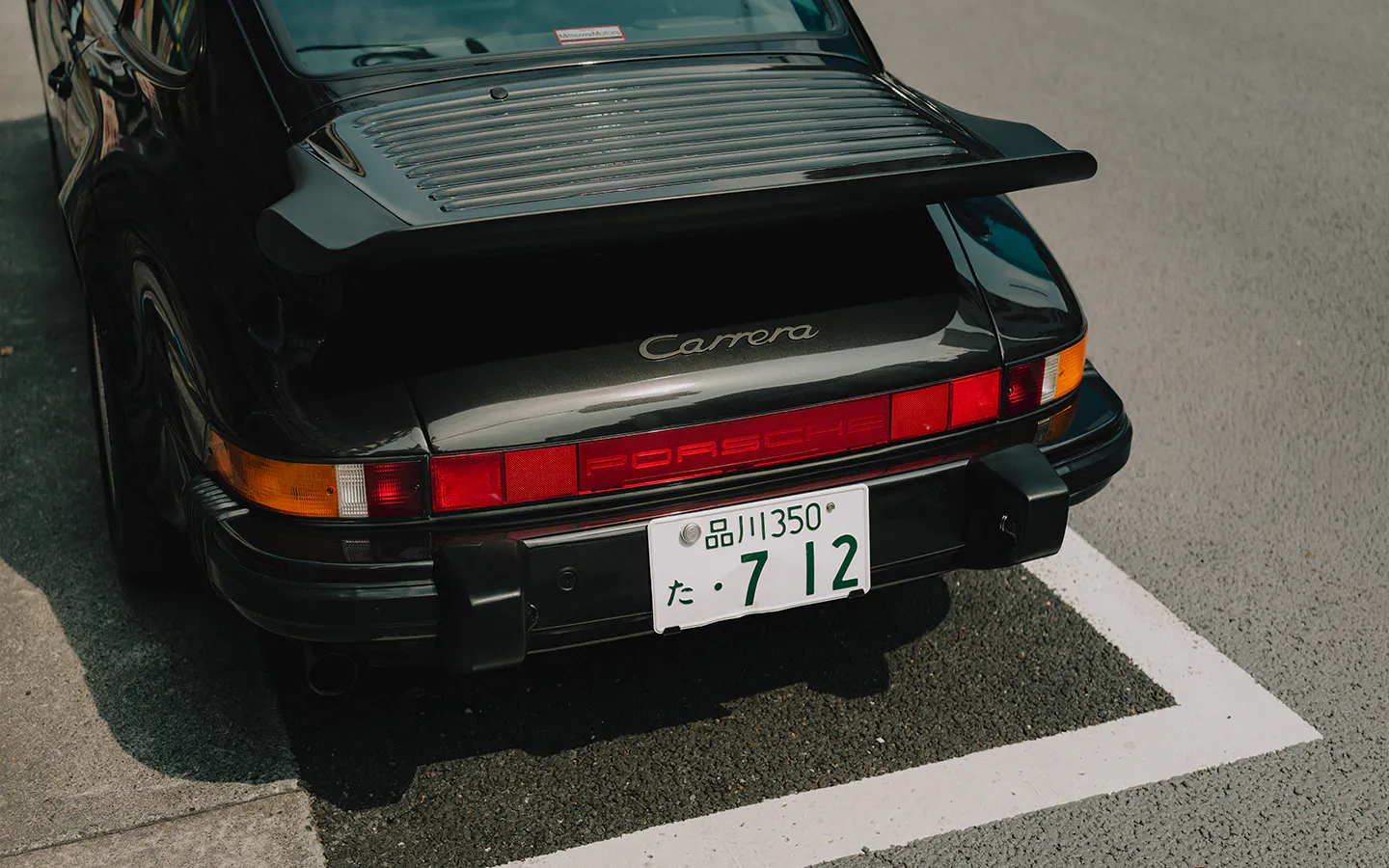 Rear view of black Porsche 911 Carrera S/C parked on Tokyo street