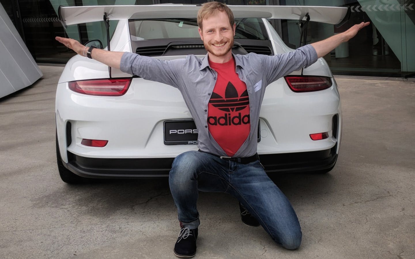 Man, arms outstretched, with Porsche 991 GT3 RS