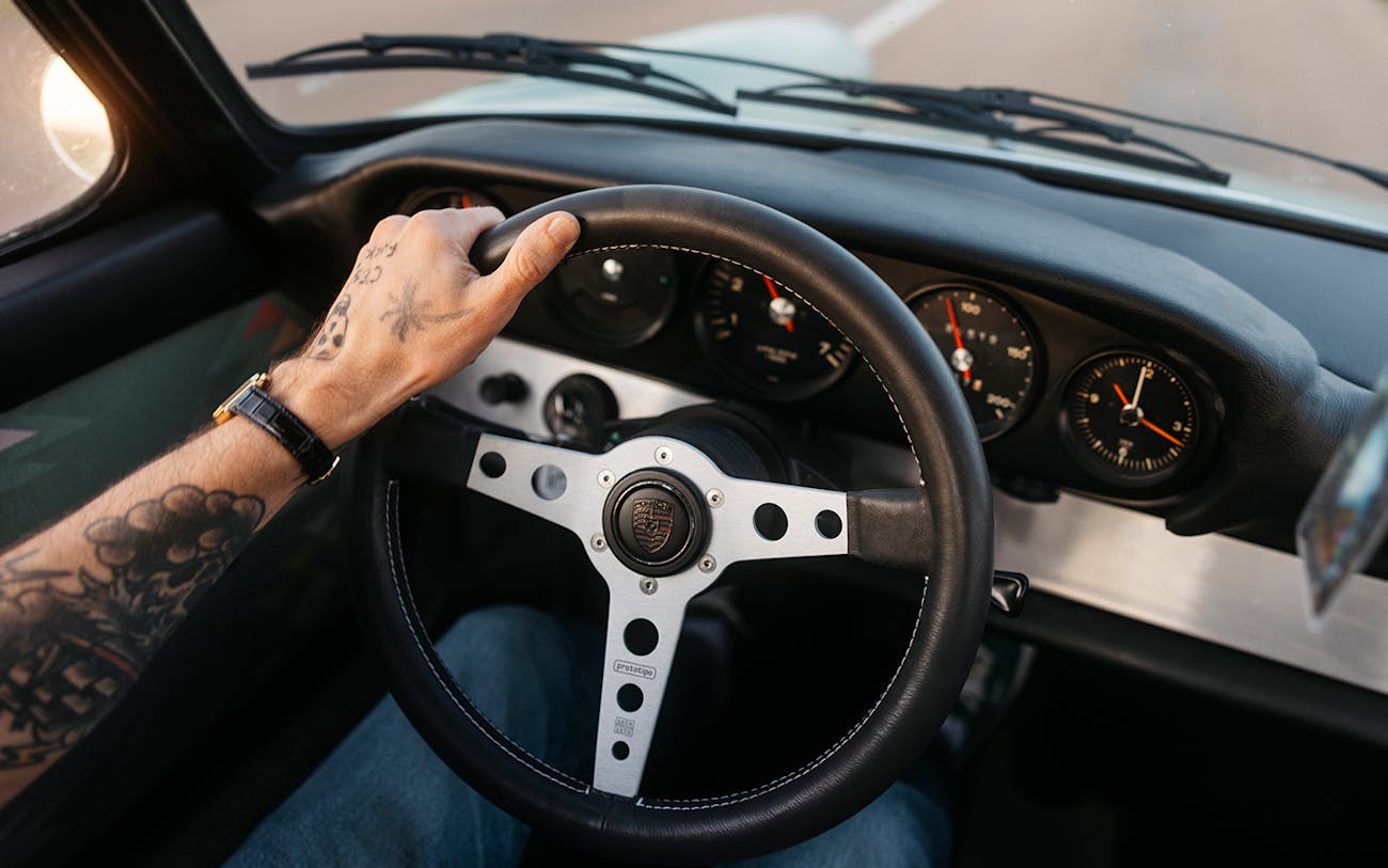 Close up of male hand on Porsche 912 steering wheel