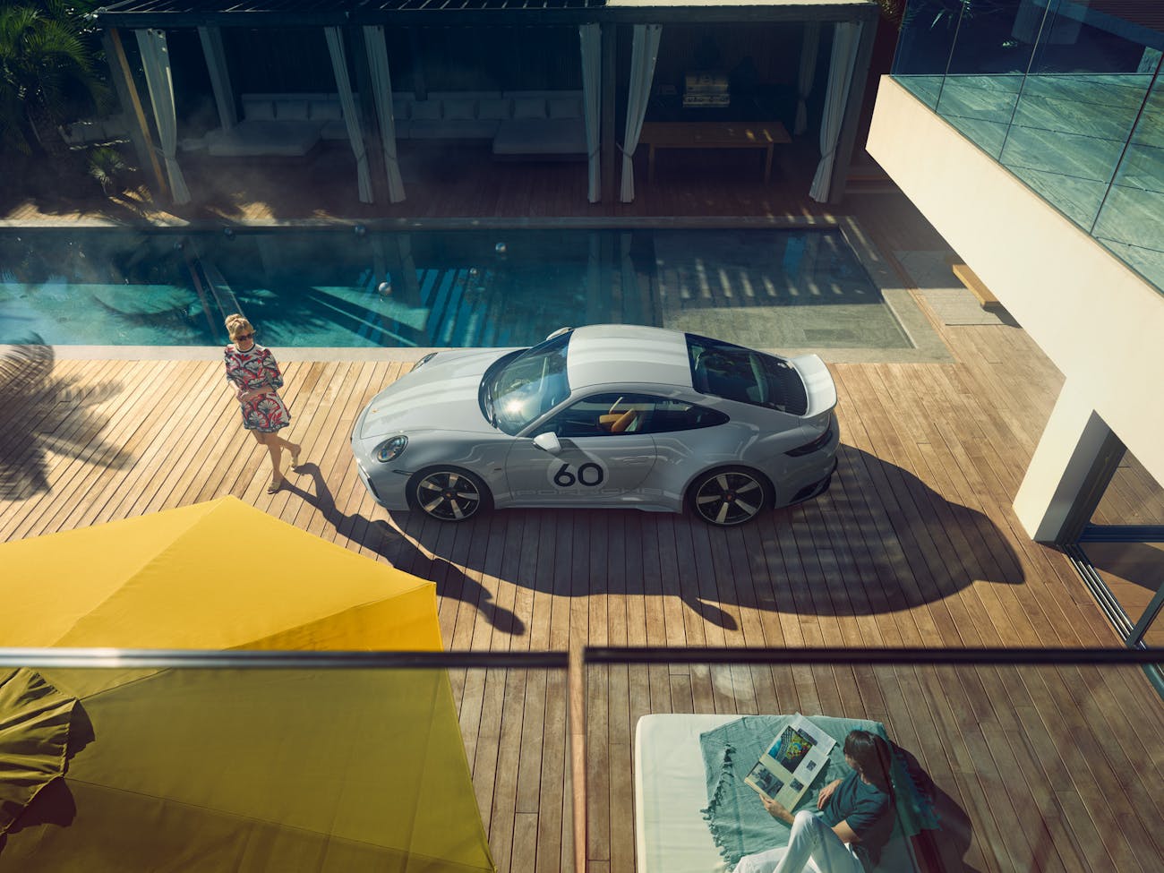 Bird’s-eye view of Porsche on decking beside swimming pool