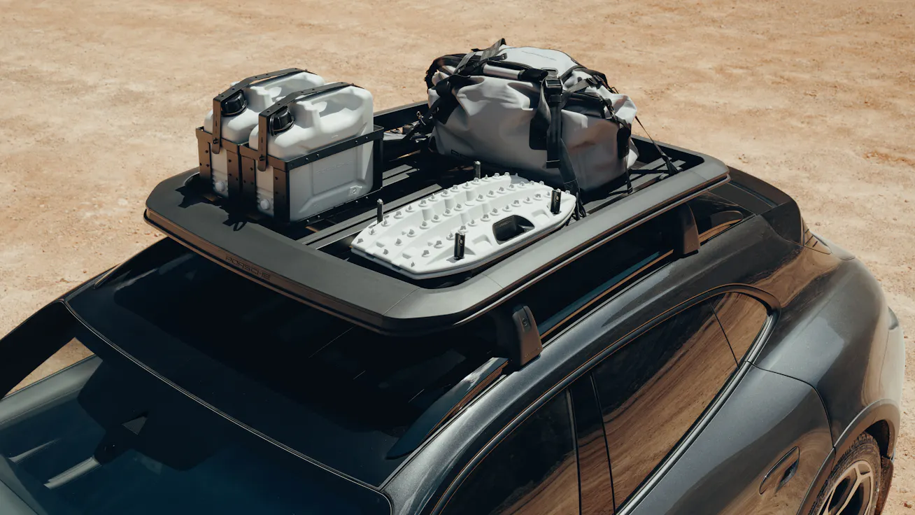 Close-up of Porsche Taycan 4 Cross Turismo fitted with Adventure Accessories and a roof basket with a bag and canisters  