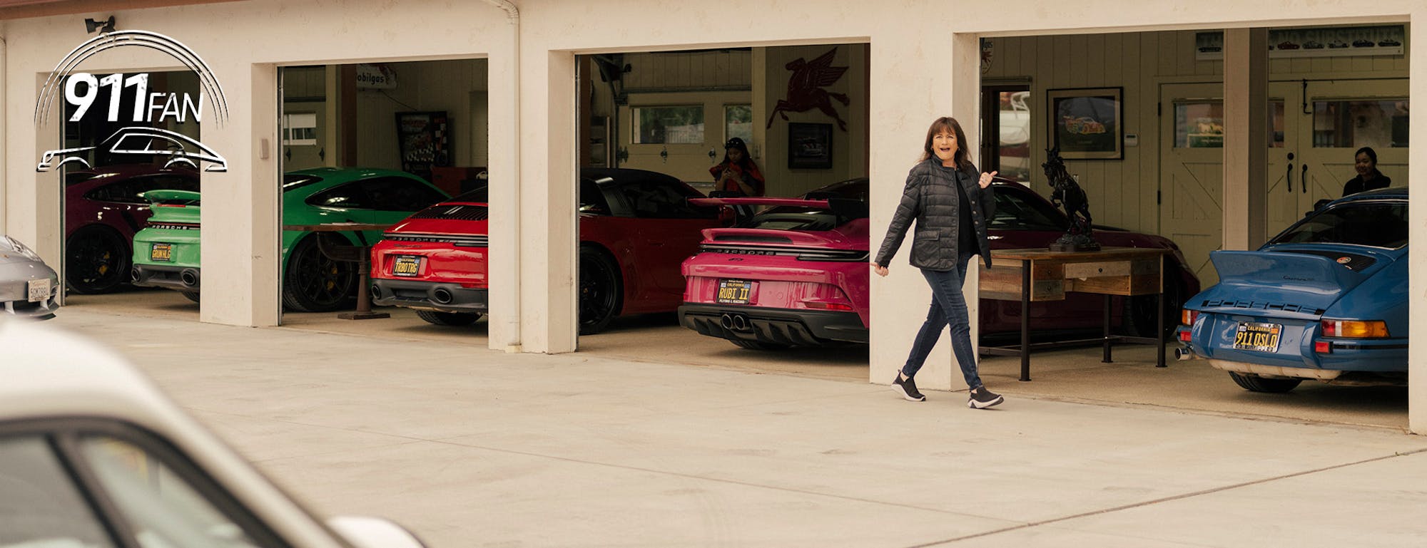 Line-up of colourful Porsche 911 cars in a garage