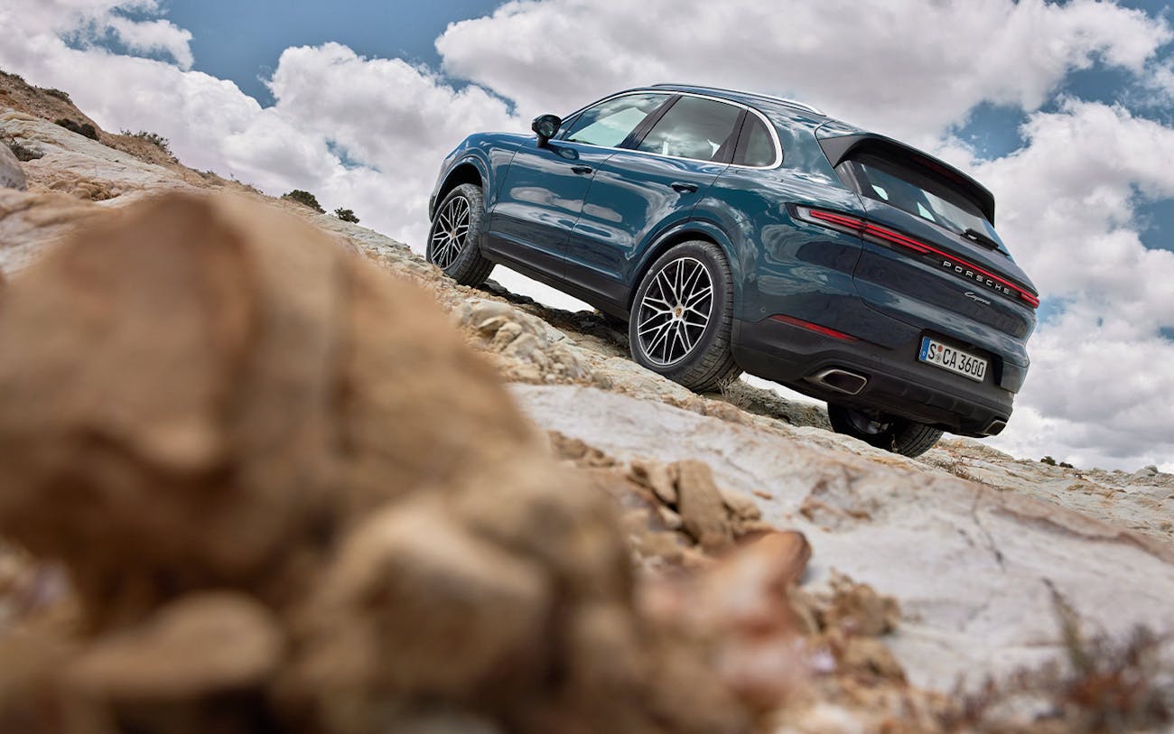 Porsche Cayenne in Montego Blue Metallic on rocky, inclined surface