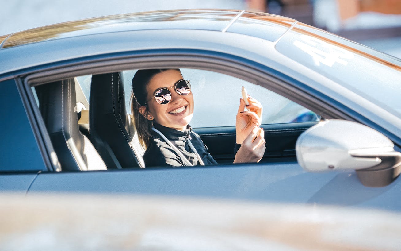 Woman laughing in a Porsche 911 at the Porsche Ice Experience