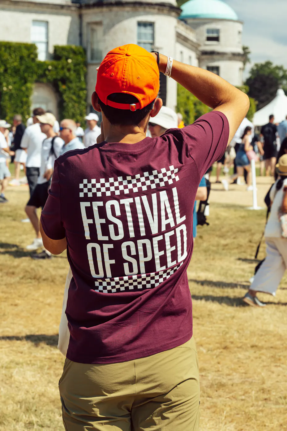 Man wearing Goodwood Festival of Speed T-shirt taking picture of Goodwood House
