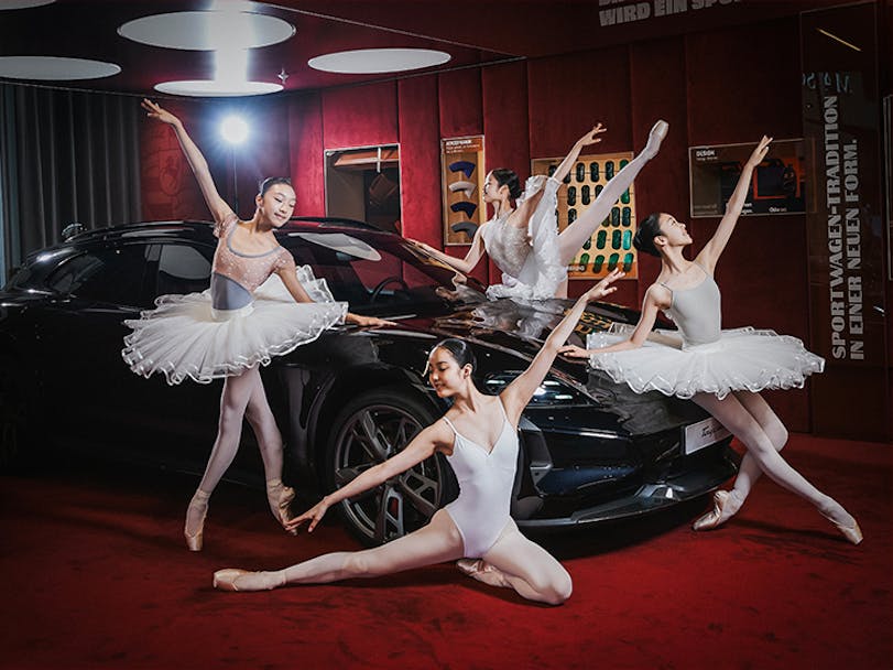 Four ballet dancers pose around Porsche Taycan Sports Turismo