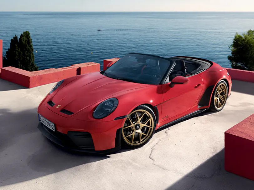 Porsche 911 GT3 S/C in Guards Red parked on roof by ocean three quarter view hero thumbnail