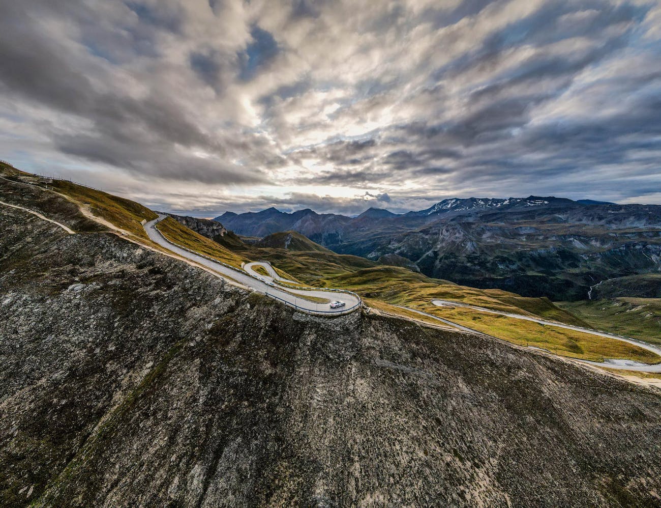 Panoramic view of mountain roads and Alps under grey skies