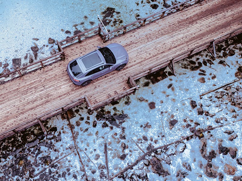 Porsche Macan Electric in Provence paint on wooden bridge in Slovenia