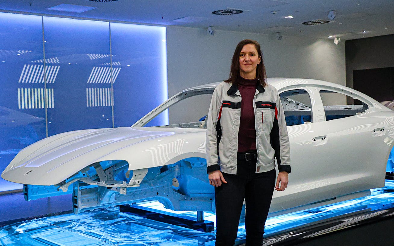 Woman standing in front of Porsche Taycan body shell