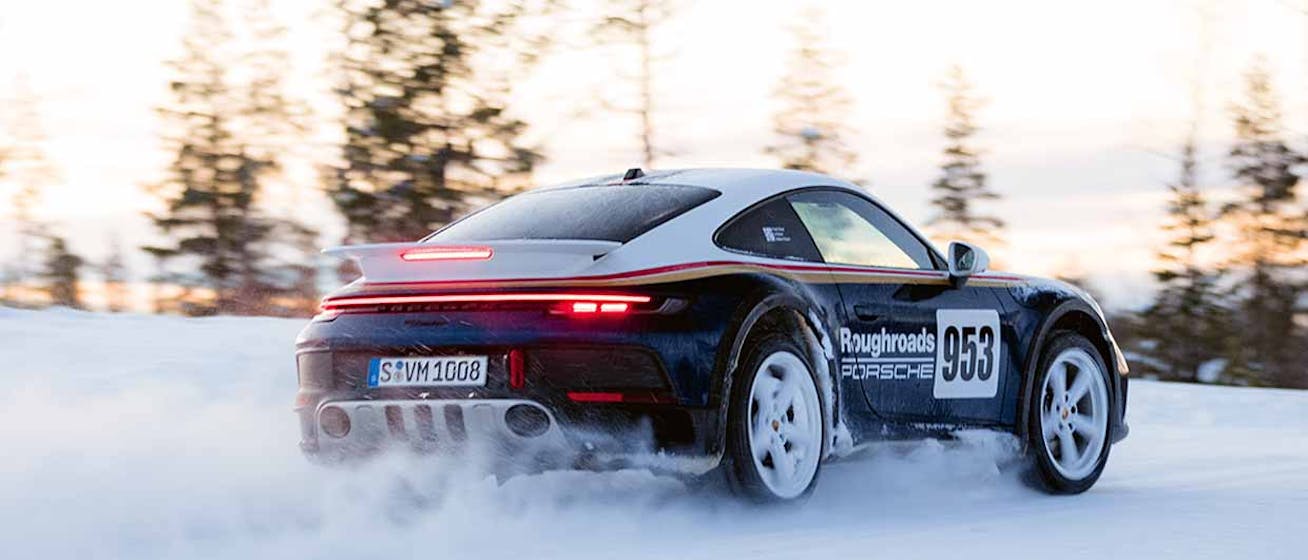 Rear view of Porsche 911 Dakar, driving on snowy track