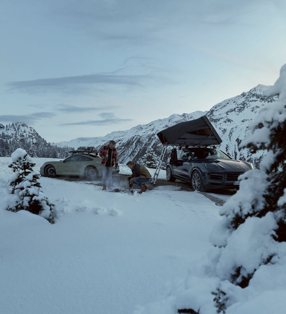 Men with Porsche cars fitted with Porsche winter camping equipment