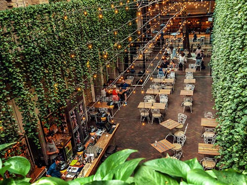 Bar tables inside an old, ivy-covered building, from above
