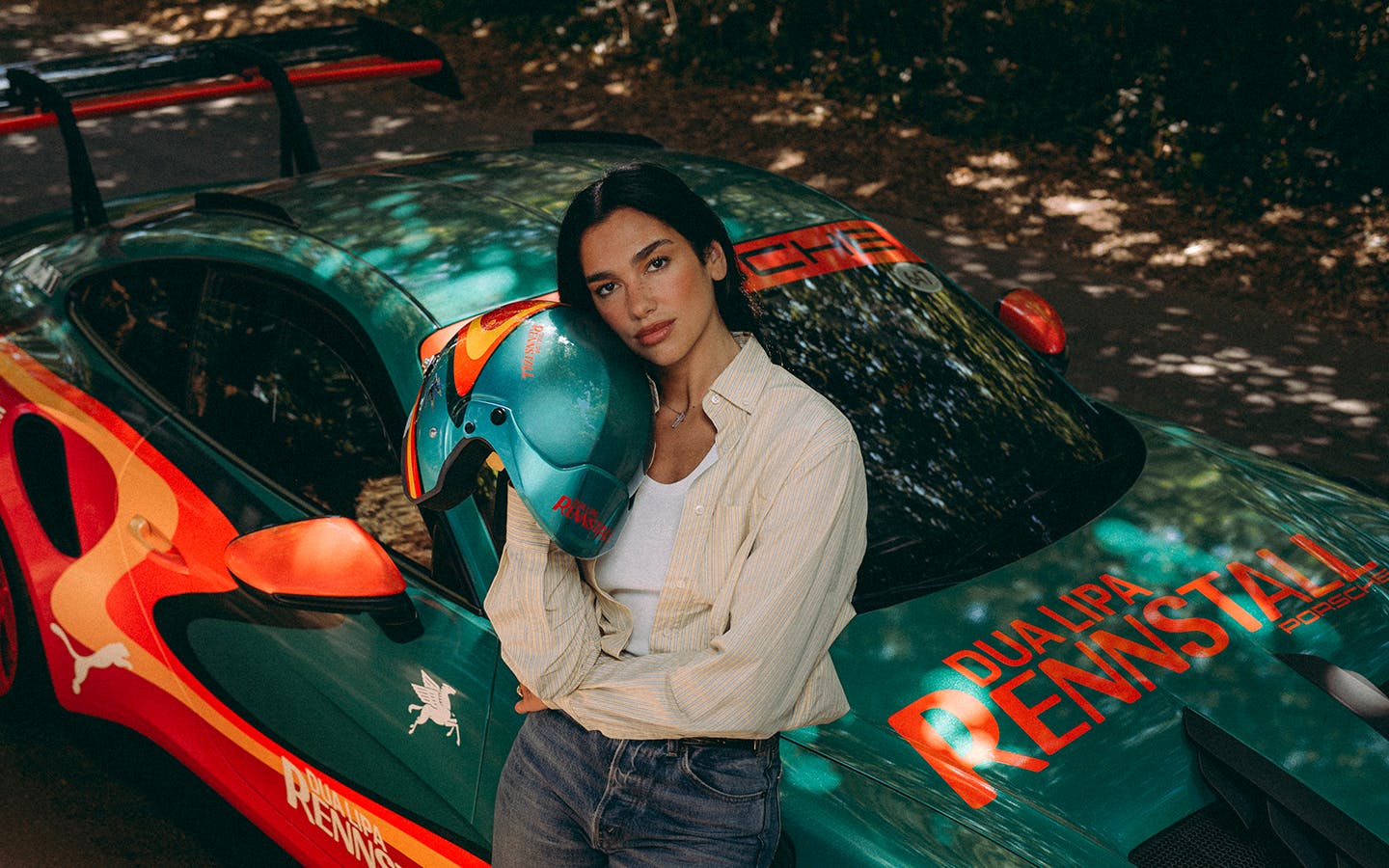 Dua Lipa with Dua Lipa Rennstall Porsche 911 GT3 RS at Goodwood Festival of Speed, holding matching race helmet