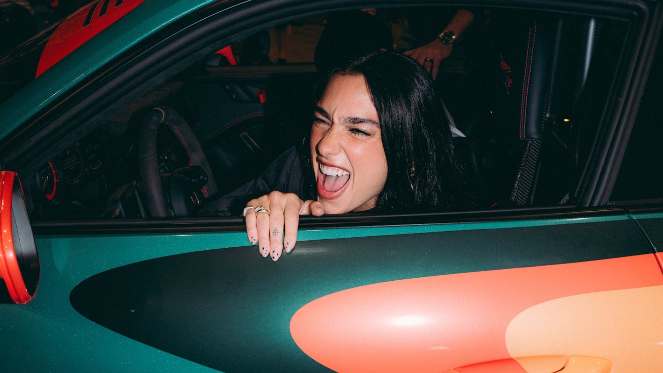 Popstar Dua Lipa leaning out of window of Porsche 911 GT3 RS