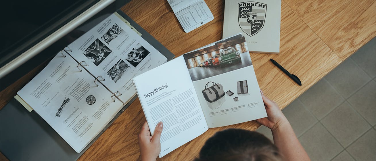 Bird’s-eye view of woman looking at Porsche ORIGINALE book 