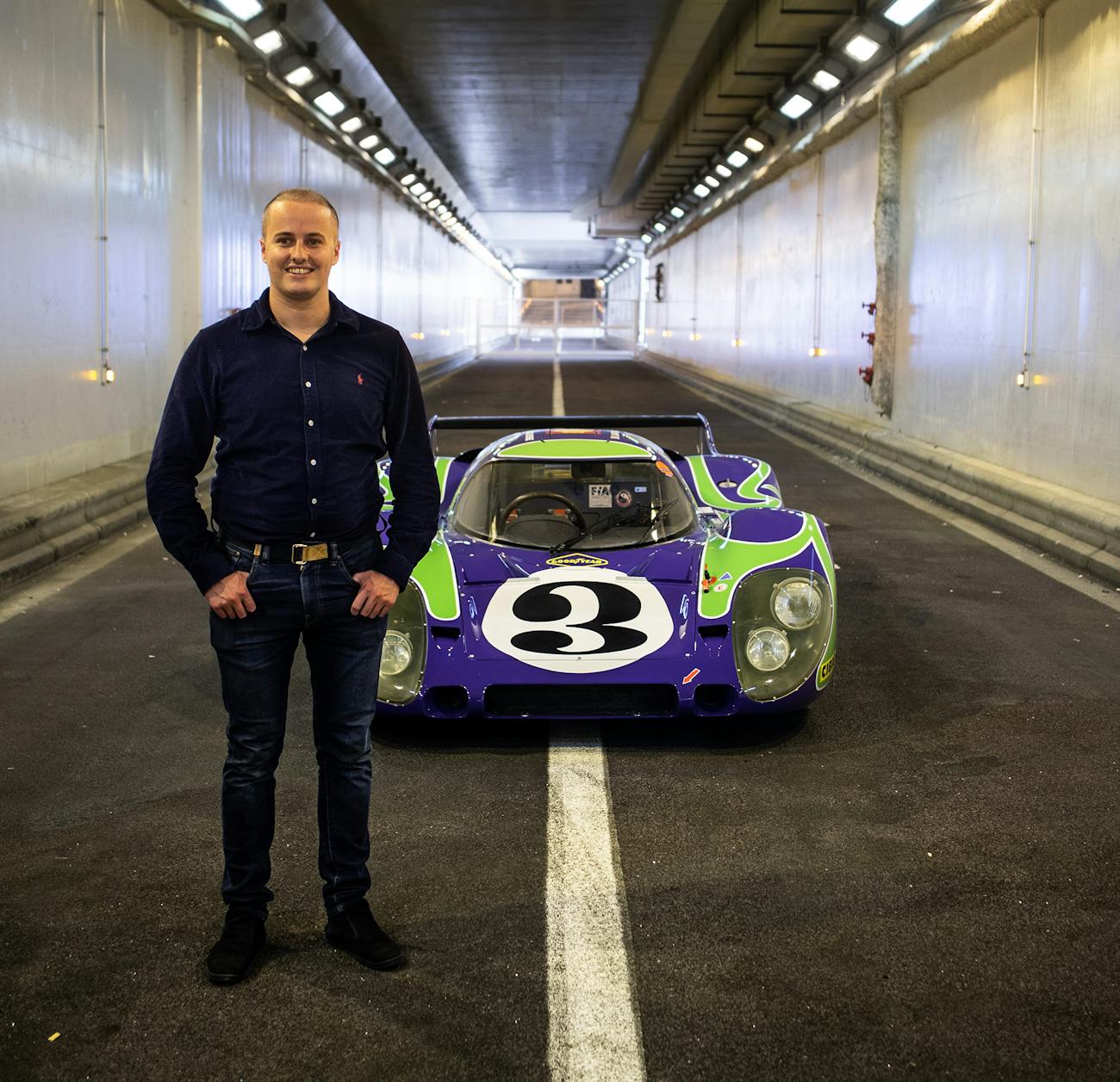 Man stands in tunnel with colourful Porsche 917 LH racecar