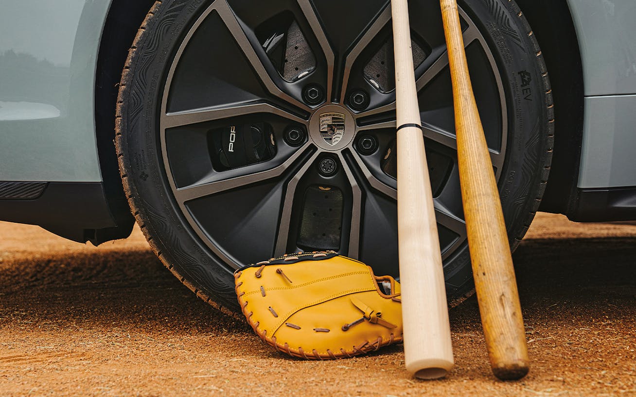 Shohei Ohtani’s baseball mitt and bats leaning on Porsche Taycan