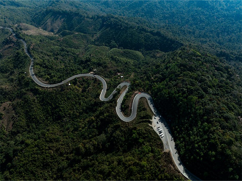 Winding mountain road through lush forest in Thailand  