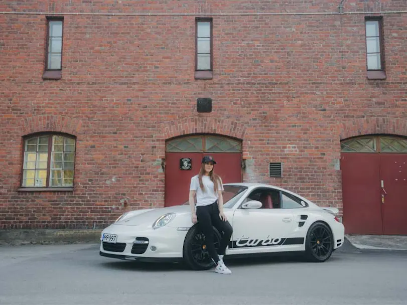 Woman standing beside porsche 911 turbo thumbnail