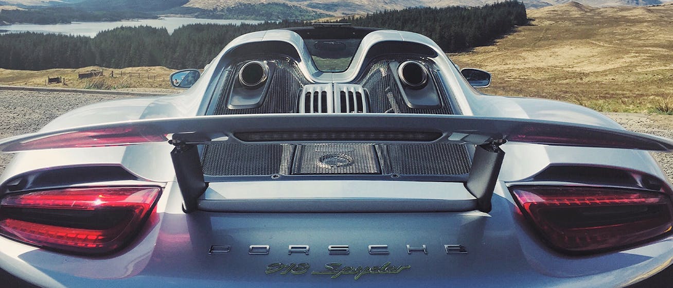 Rear view of Porsche 918 Spyder, mountains and lake behind