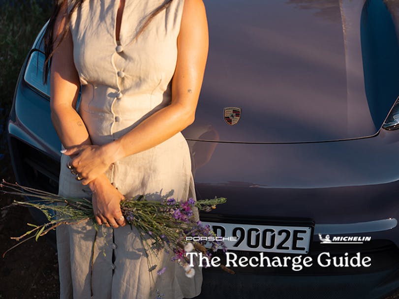 Close-up of person holding lavender, Porsche Macan behind