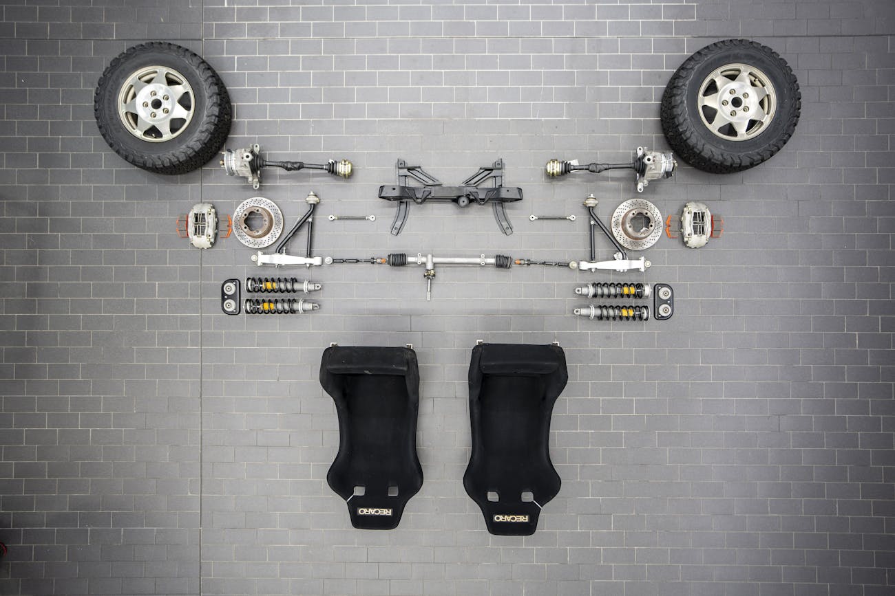 Birdseye view of disassembled car including seats, wheels and axles