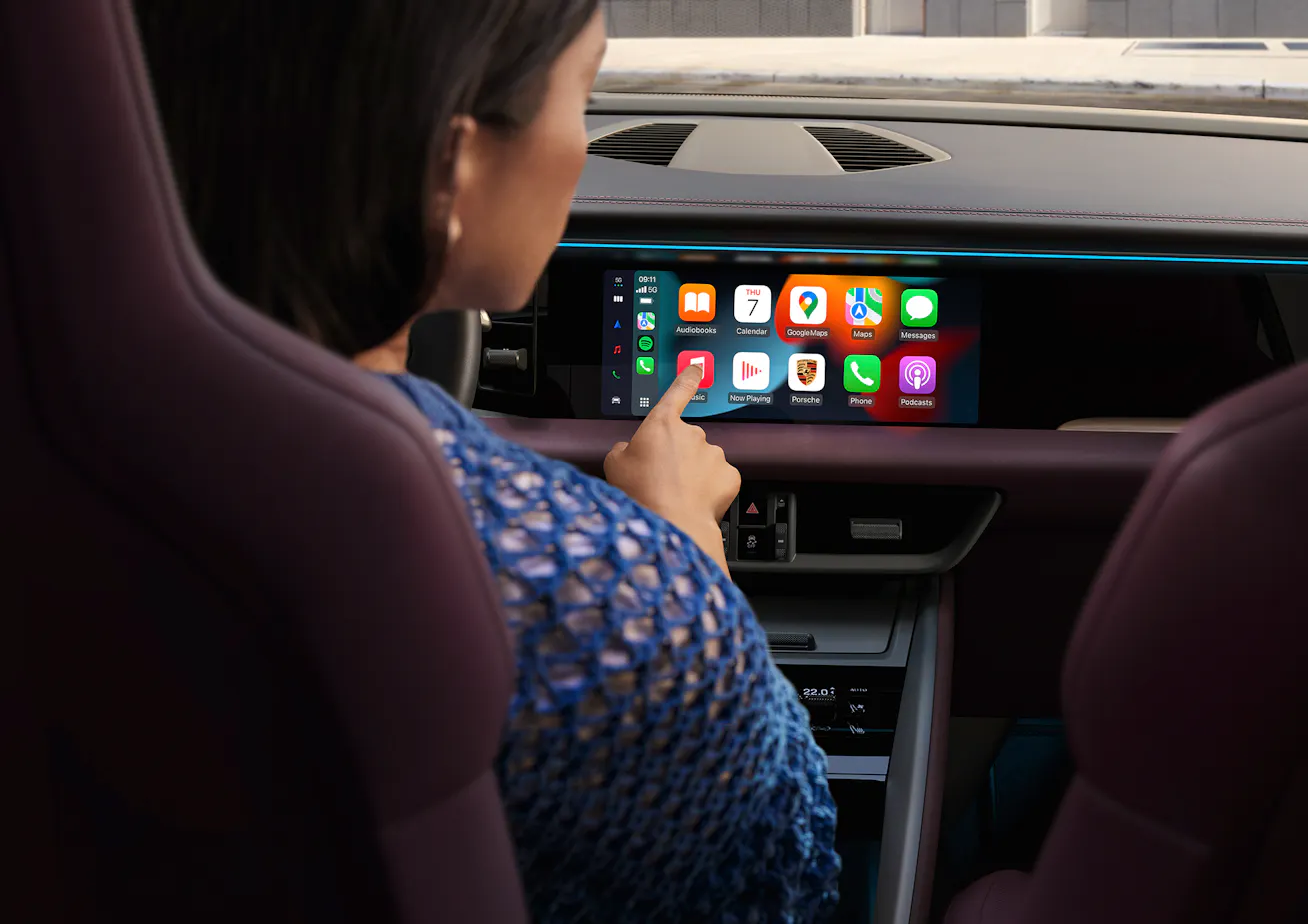 Woman using Porsche infotainment display with Apple CarPlay