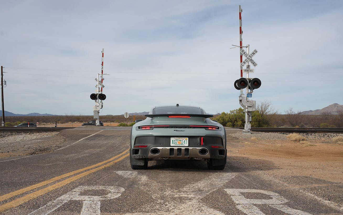 Rear view of Porsche 911 Dakar at train track crossing