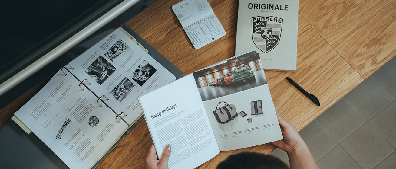 Bird's-eye view of woman flipping through magazines on desk