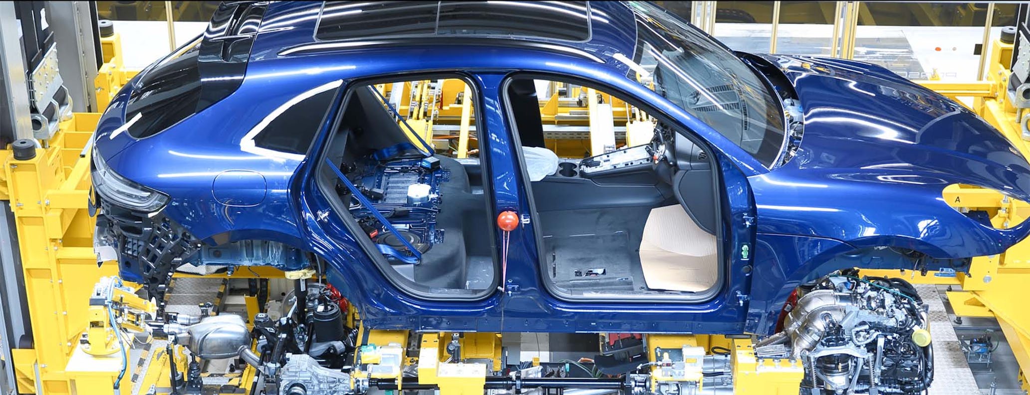 Picture of Porsche Macan on a robotic conveyor belt on the production line in the Porsche factory