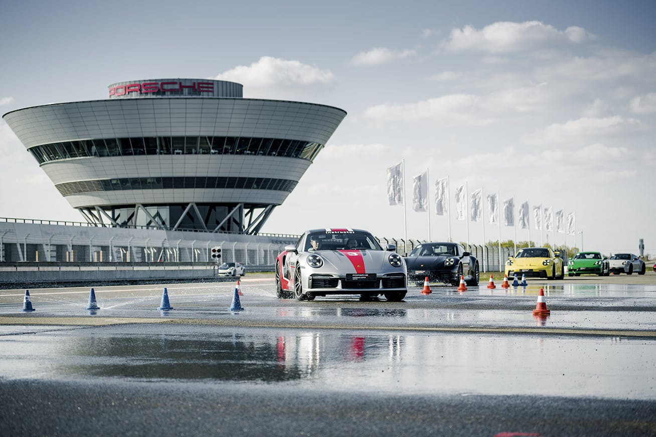 Line of cars at Porsche Experience Center Leipzig, tower behind
