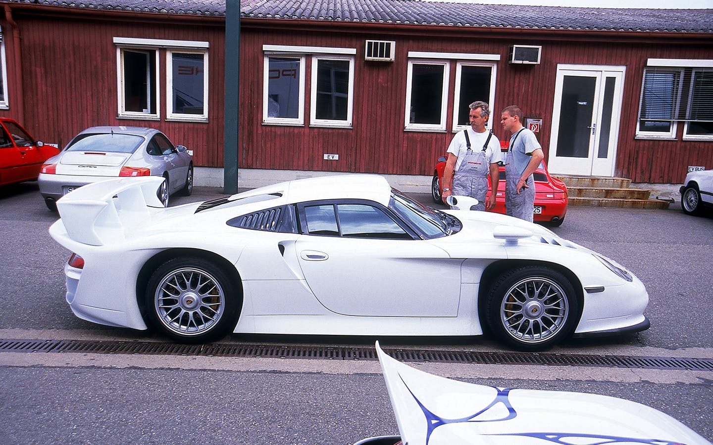 Two men admiring a parked Porsche 911 GT1 Strassenversion