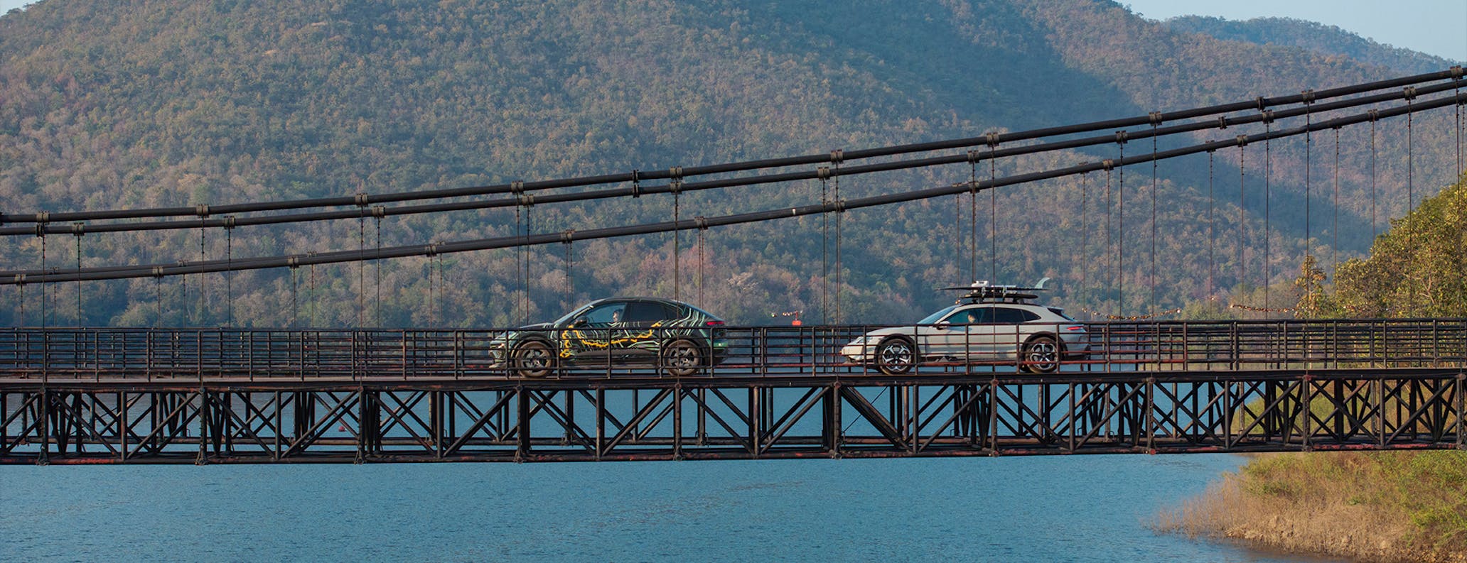 Macan 4S and Taycan Turbo Cross Turismo driving across bridge in Thailand 