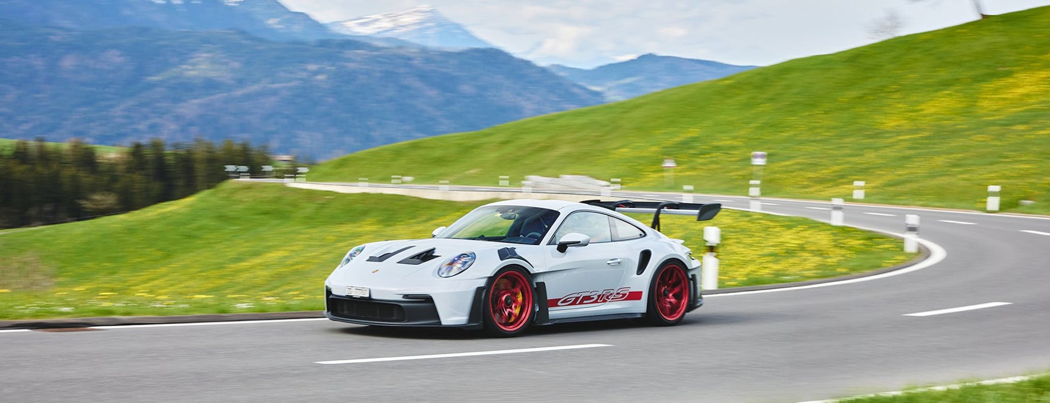 Porsche 911 GT3 RS (type 992) cornering on Alpine road