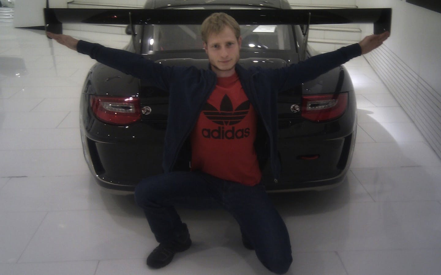 Man, arms outstretched, with Porsche 997 GT3 RS