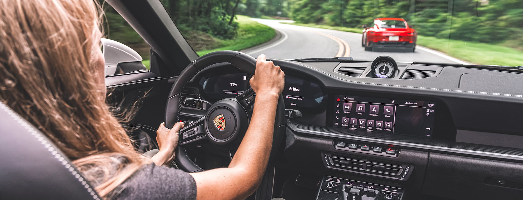 Interior of car, woman driving Porsche 911 cabriolet on road