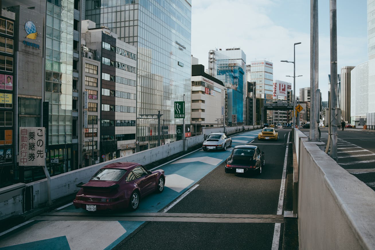 Classic air-cooled Porsche 911 models driving along the disused KK Line elevated expressway in central Tokyo